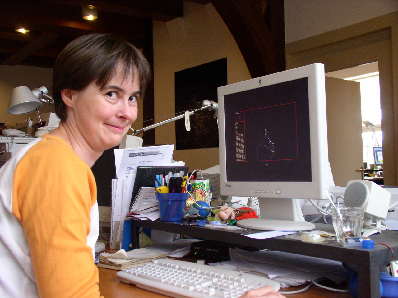 Bente sits at a desk with a screen showing the AmsterdamREALTIME interface